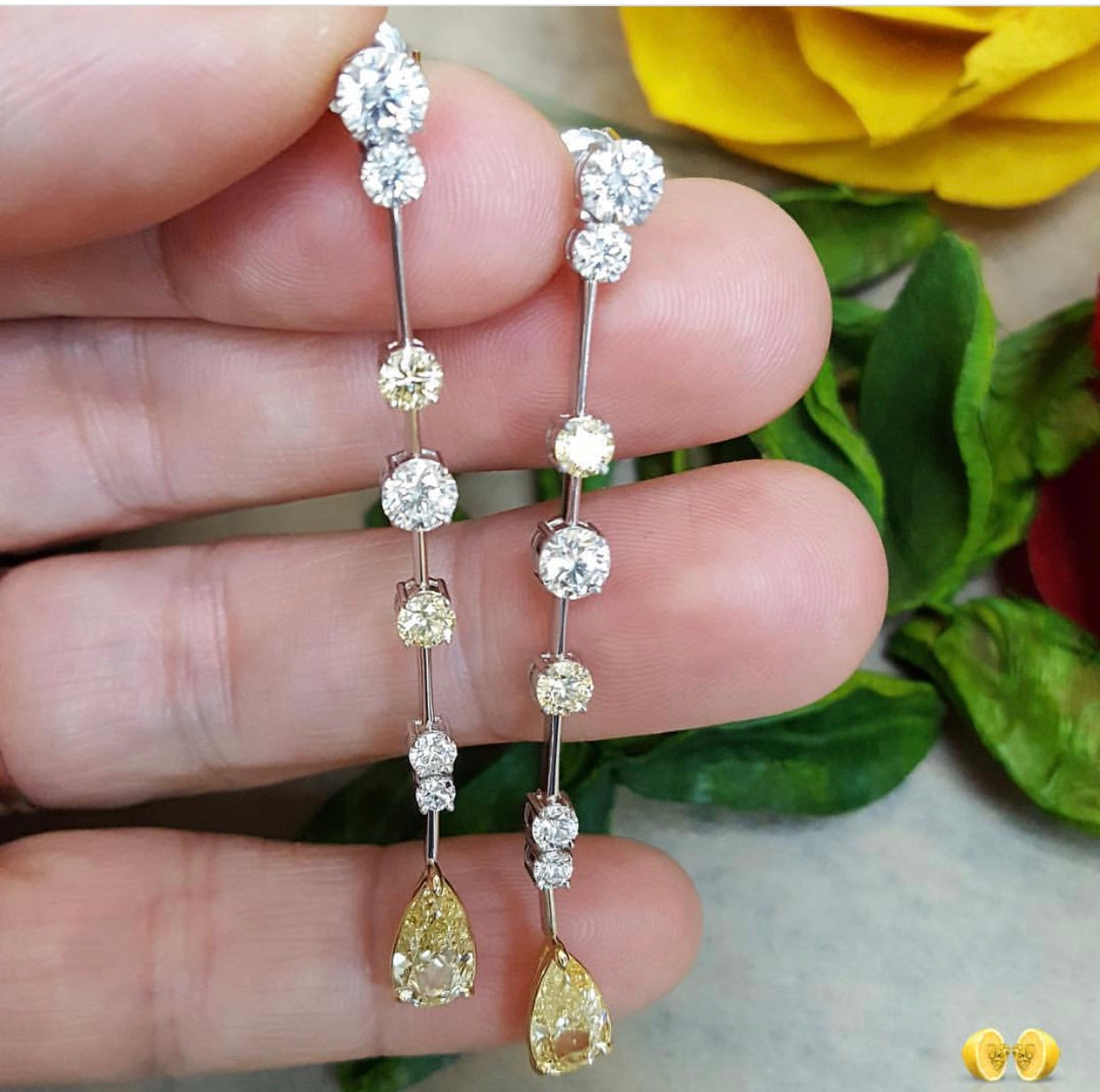 Elegant diamond earrings featuring a series of round white diamonds and teardrop-shaped yellow diamonds, set in white gold. Available in NYC.