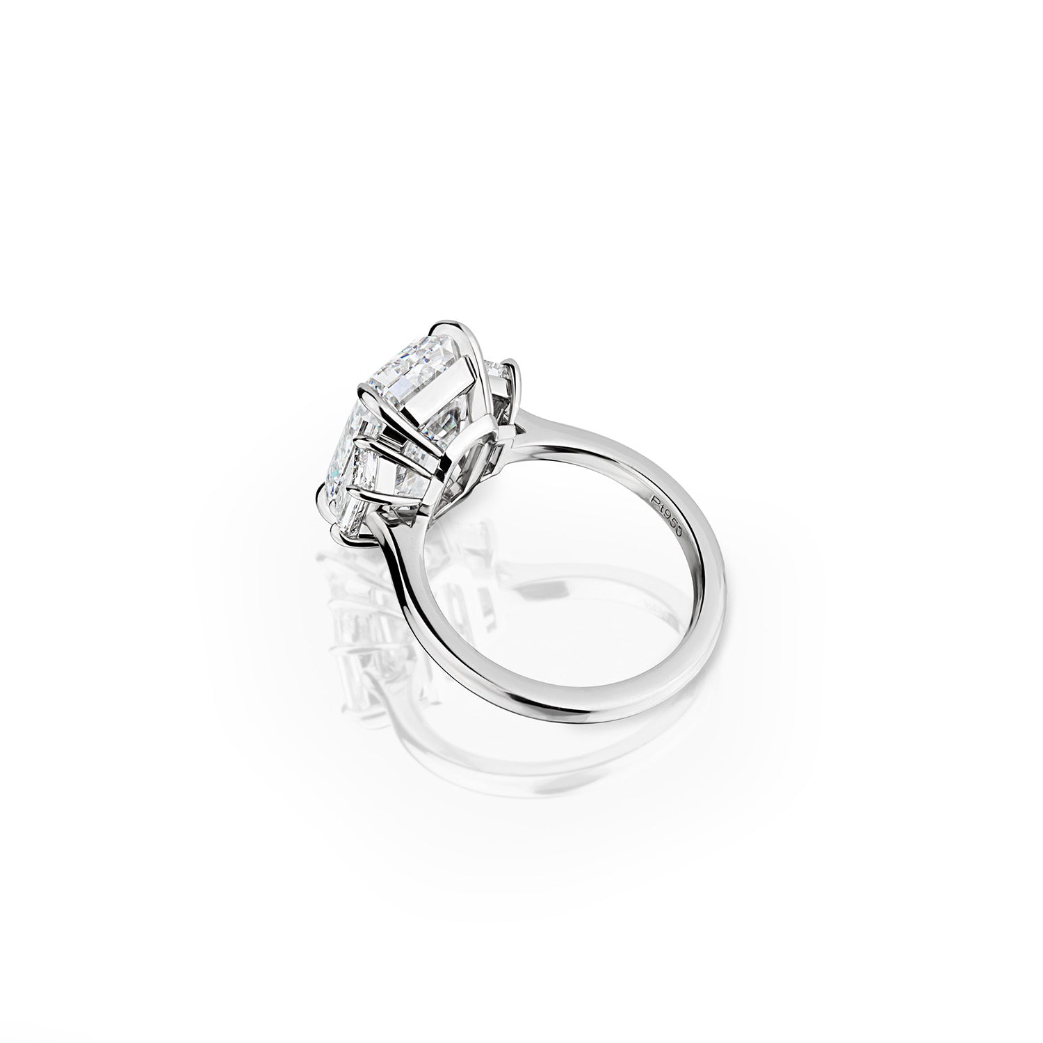 GIA-certified emerald and trapezoid cut three stone diamond ring, featuring a striking 7.57 carat center stone and 1.01 carats in side stones, set in platinum. Available for custom orders to suit any style preference.