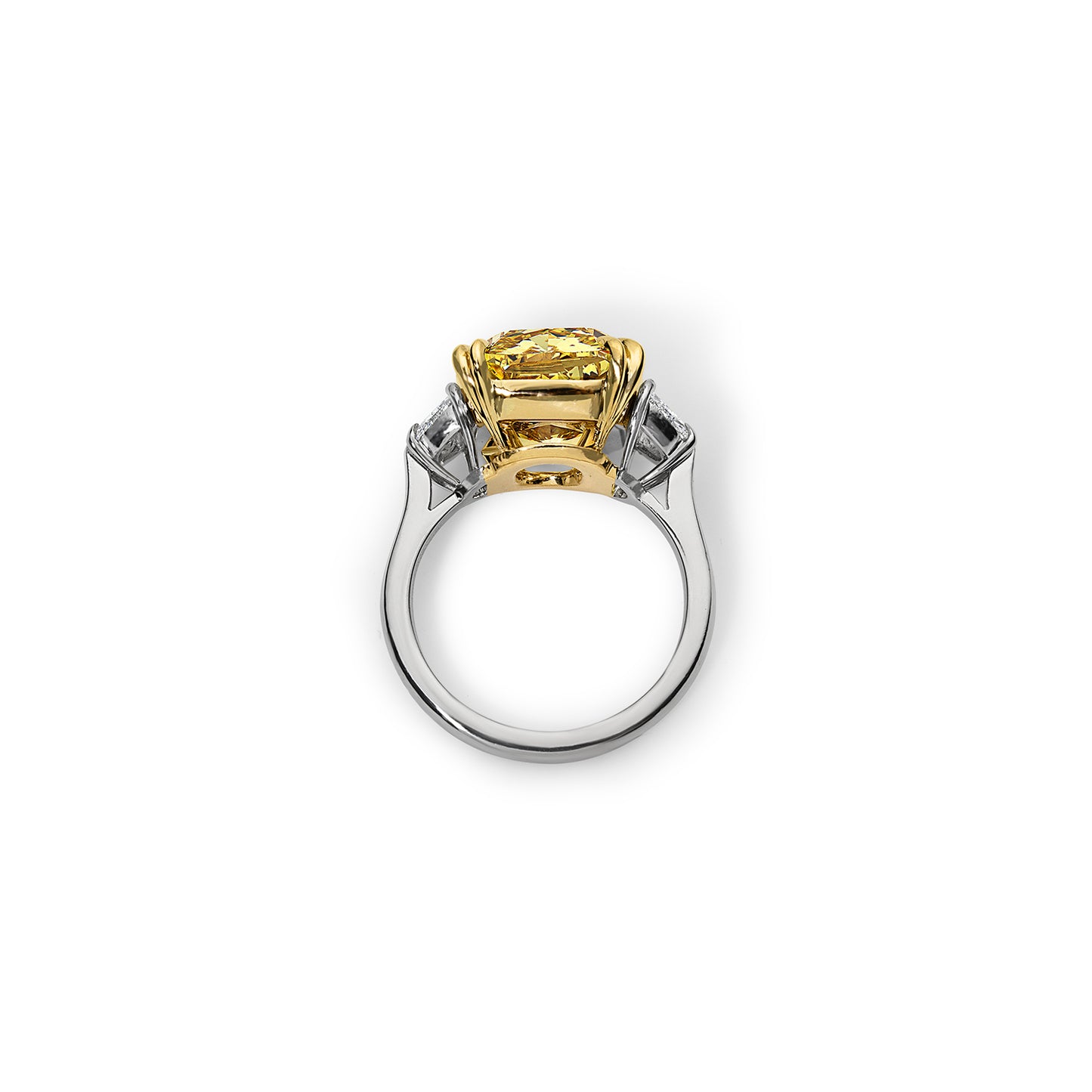 Side view of a 6.80 carat vivid yellow diamond three stone ring with colorless trapezoid cut diamonds, set in handmade platinum and yellow gold.